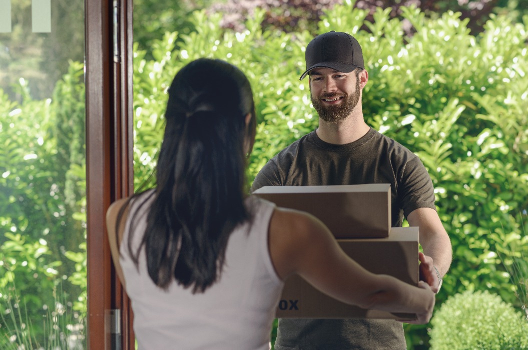 Kurier übergibt einer Frau ein Paket